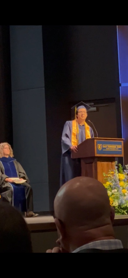 Alvin Tai speaking at a podium